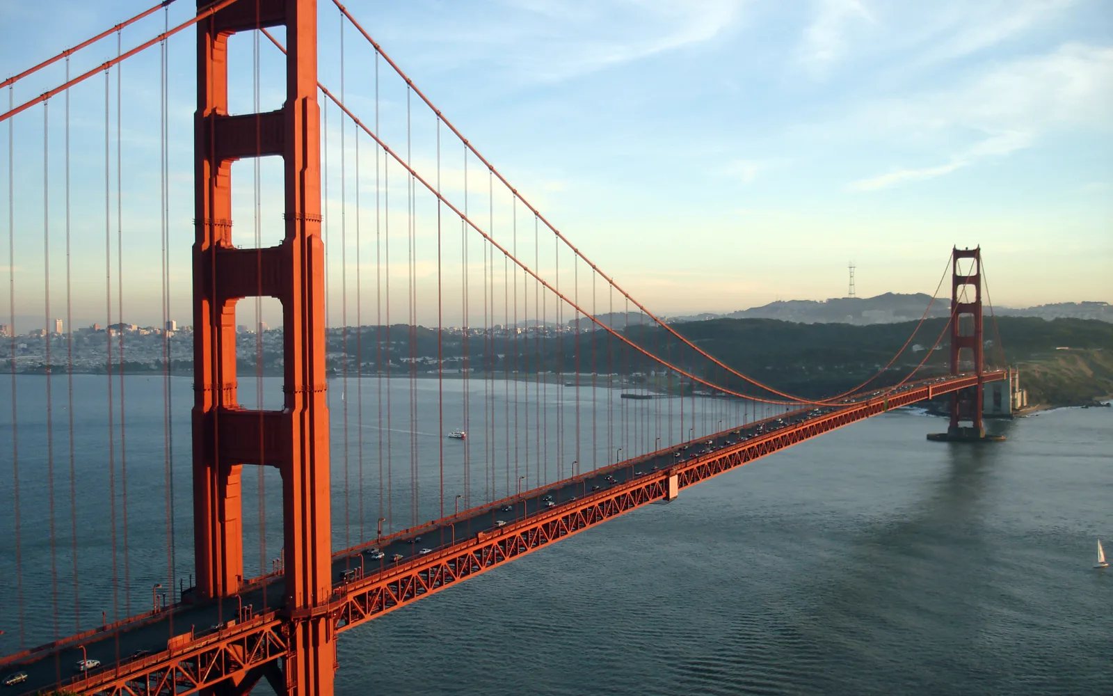 The Golden Gate Bridge at sunset, viewed from Marin Headlands, with the bridge cables illuminated against the evening sky